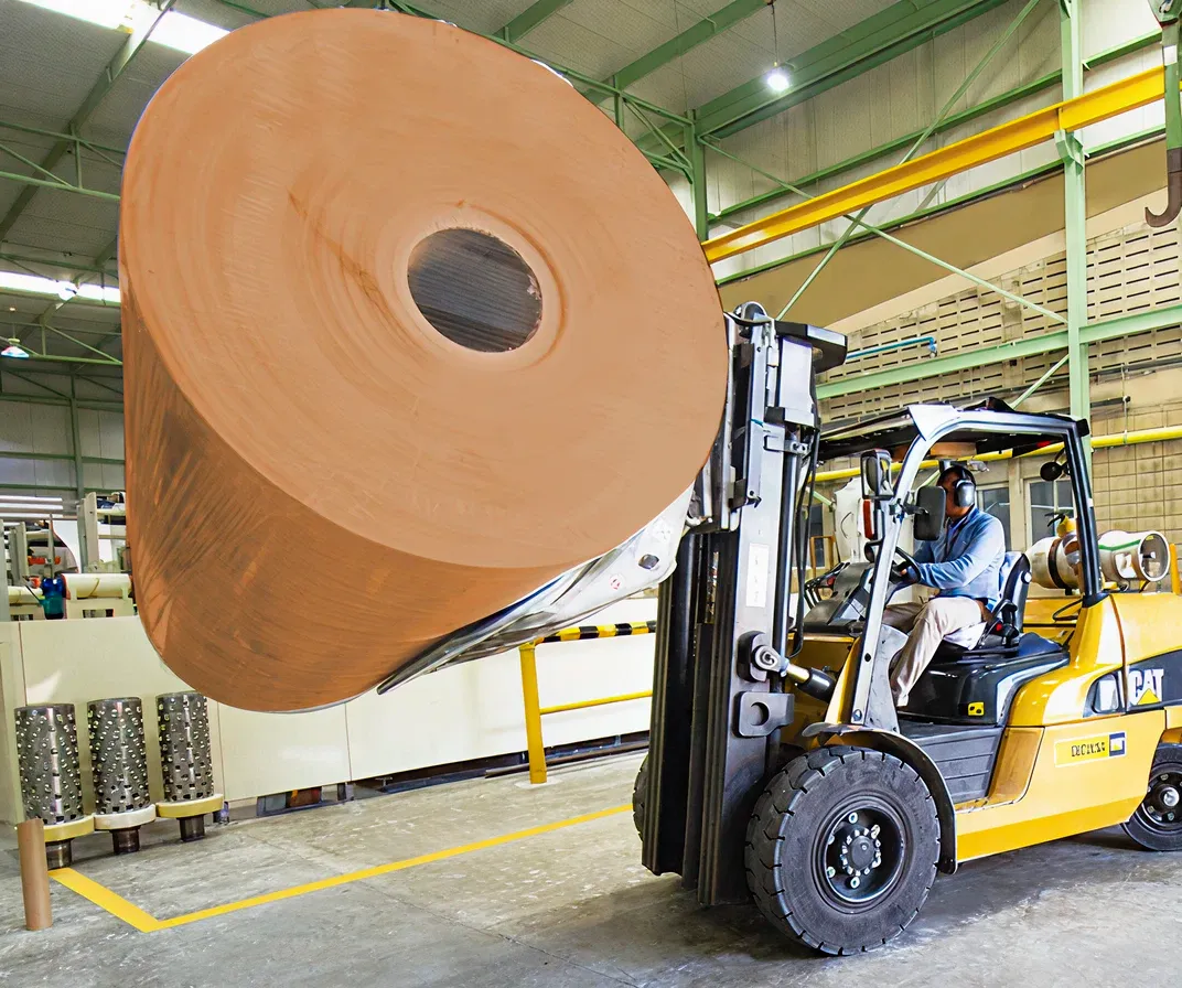 Maquinaria levantando bobina de kraft